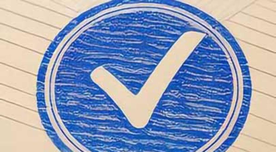 A bold blue check mark inside a circular border printed on lined paper.